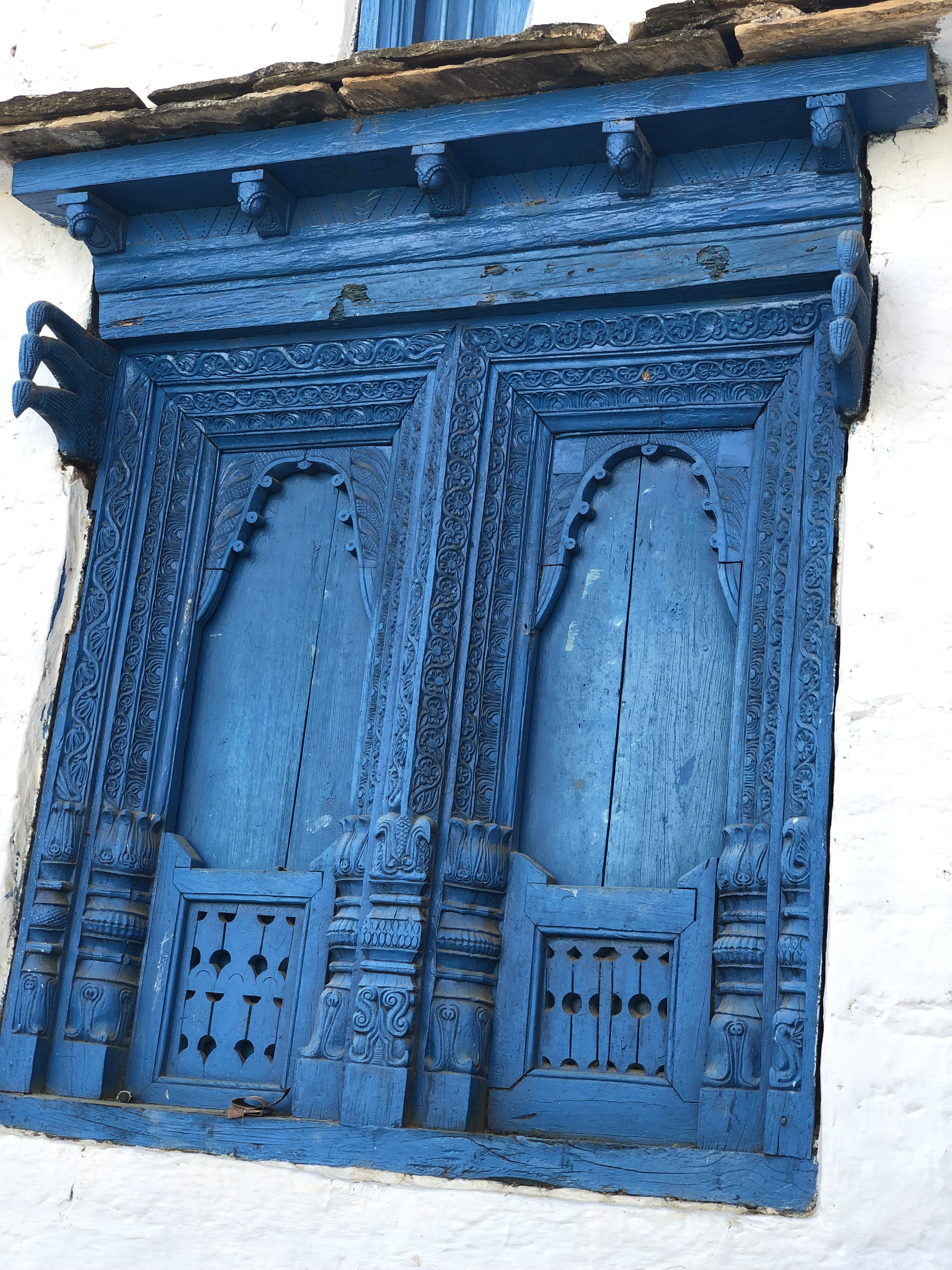 Intricate wood work done in a traditional Kumaoni style (Likhai). One can see various patterns in the window. 