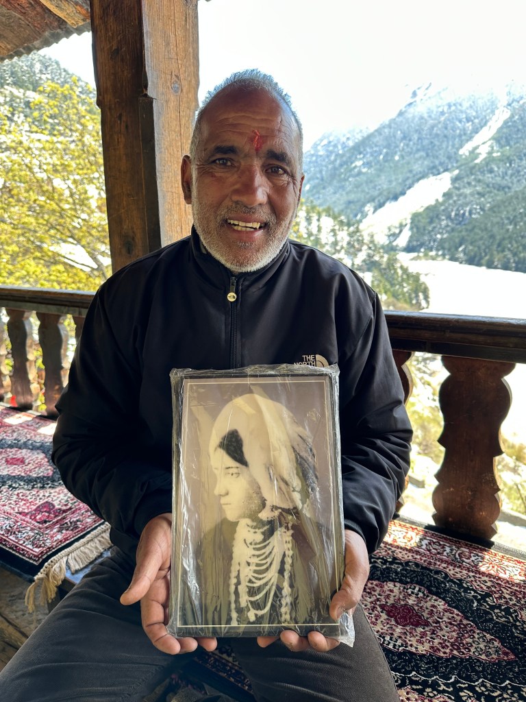Prem Chand holding a the portrait of Raimatta (Wilson's 1st wife) at his house in Mukhba village.
